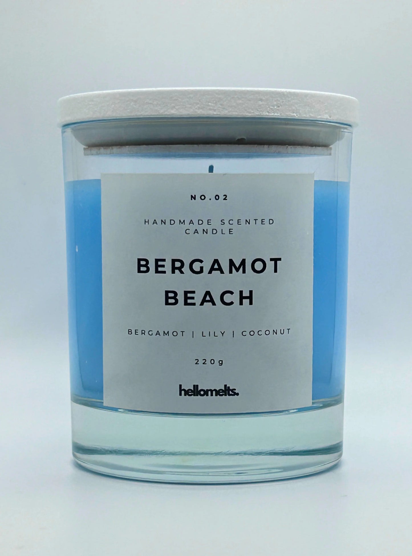 Bergamot Beach 220g candle, with lid on, by Hellomelts, infused with refreshing bergamot, lily and a hint of coconut, in a beach-inspired blue wax.