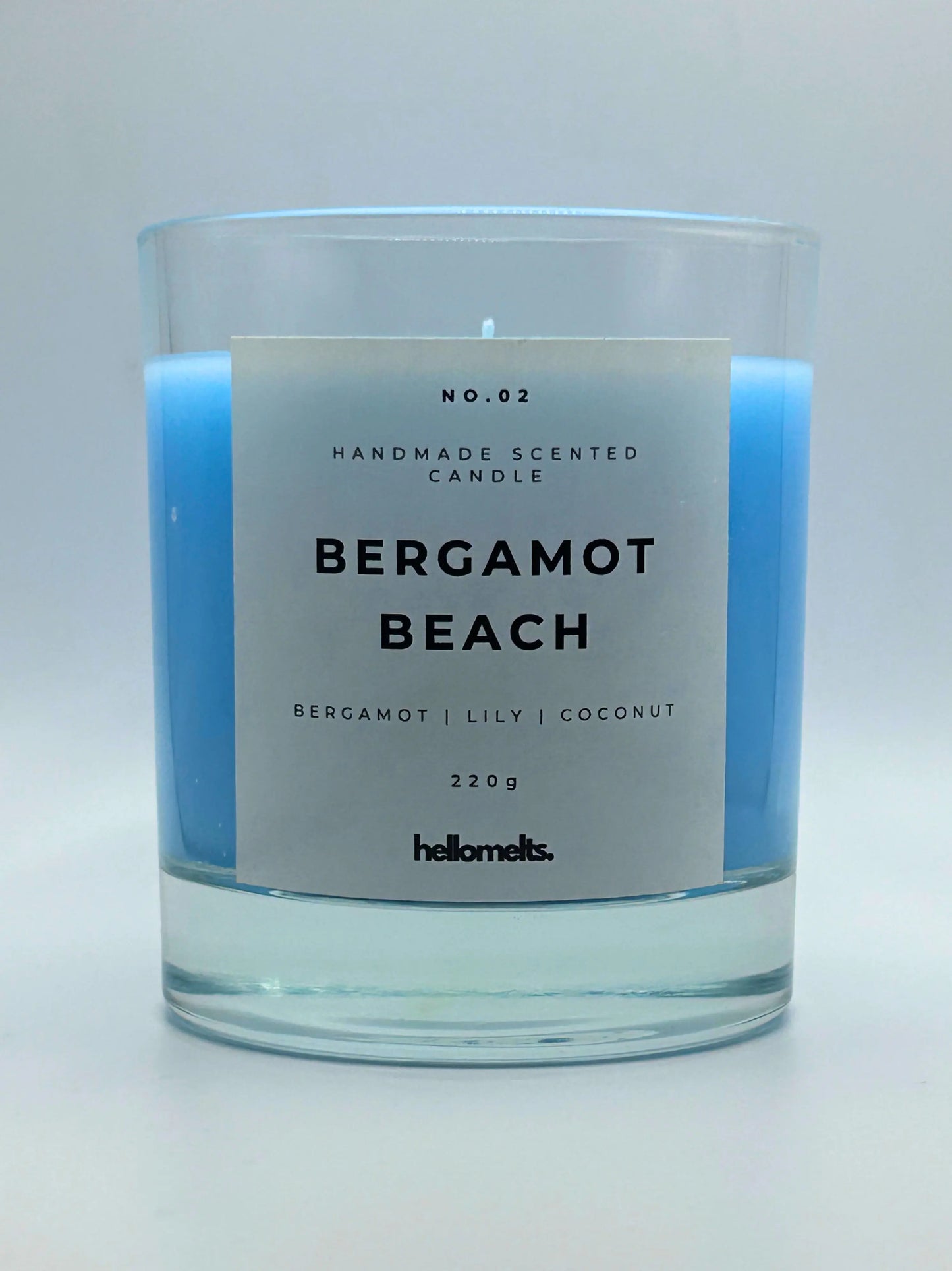 Bergamot Beach 220g candle, with no lid, by Hellomelts, infused with refreshing bergamot, lily and a hint of coconut, in a beach-inspired blue wax.