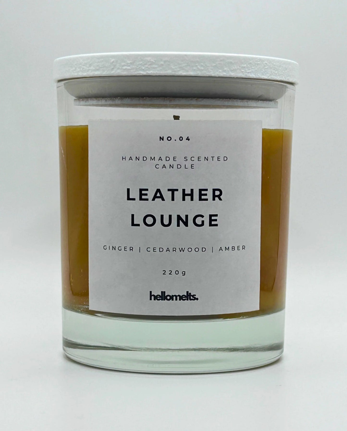 Leather Lounge 220g candle, with lid on, by Hellomelts, infused with notes of ginger, cedarwood, and amber, captured in a brown wax to resemble leather.