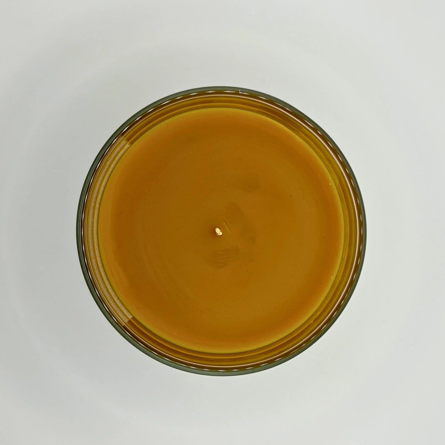 Leather Lounge 220g candle, showing top view of wax, by Hellomelts, infused with notes of ginger, cedarwood, and amber, captured in a brown wax to resemble leather.