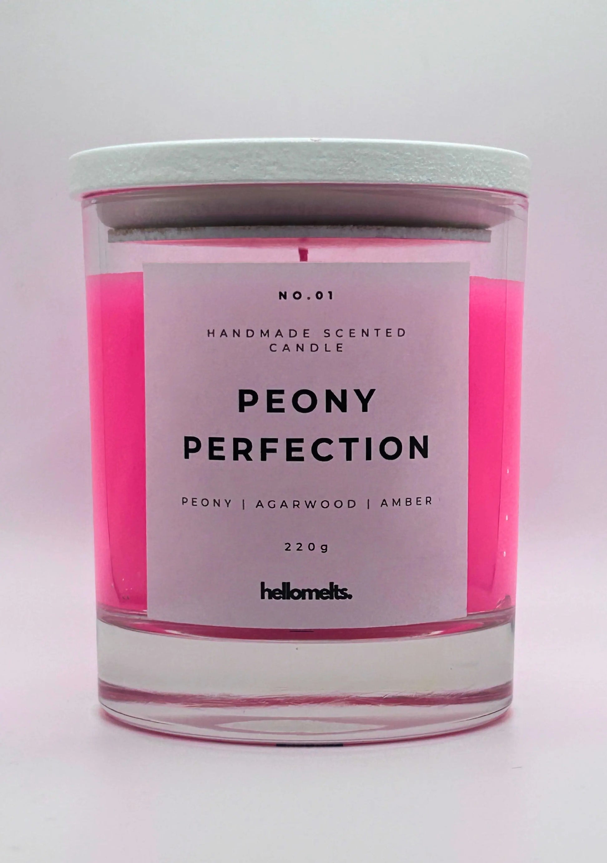 Peony Perfection 220g candle, with lid on, by Hellomelts, exuding delicate peony, luxurious agarwood, and warm amber aromas, in a beautiful bright pink wax.