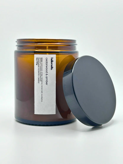 Front view of Cedarwood & Amber candle by Hellomelts with the lid placed beside it, part of the autumn collection.