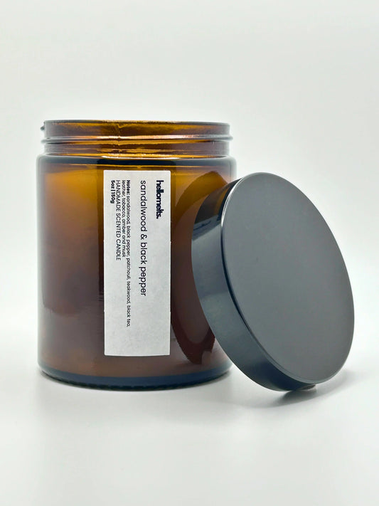 Front view of Sandalwood & Black Pepper candle by Hellomelts with the lid placed beside it, part of the autumn collection.